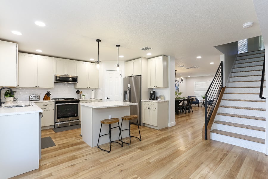 Modern, fully equipped kitchen with stainless steel appliances, a spacious island with bar seating, and an open layout that flows into the dining area - perfect for cooking and entertaining. 