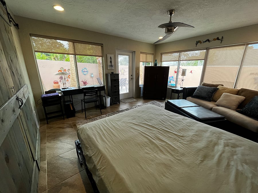 Murphy bed and barn doors makes the sunroom a private and spacious sleeping area with a magical view of lighted palm trees in the courtyard at night.