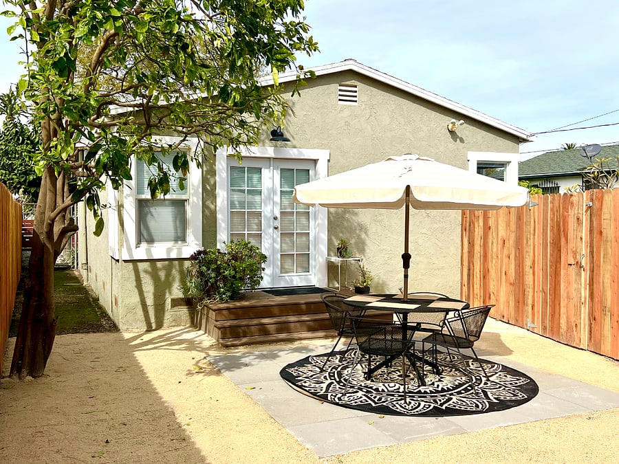 The King suite leads to the fully fenced backyard, featuring a shaded patio set and a fire pit lounge. This yard is also accessible through the driveway gate.