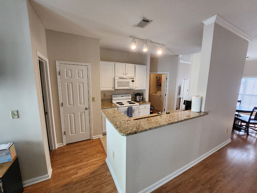 View of the kitchen from the living room. You can also see the laundry room and dining room from this angle.