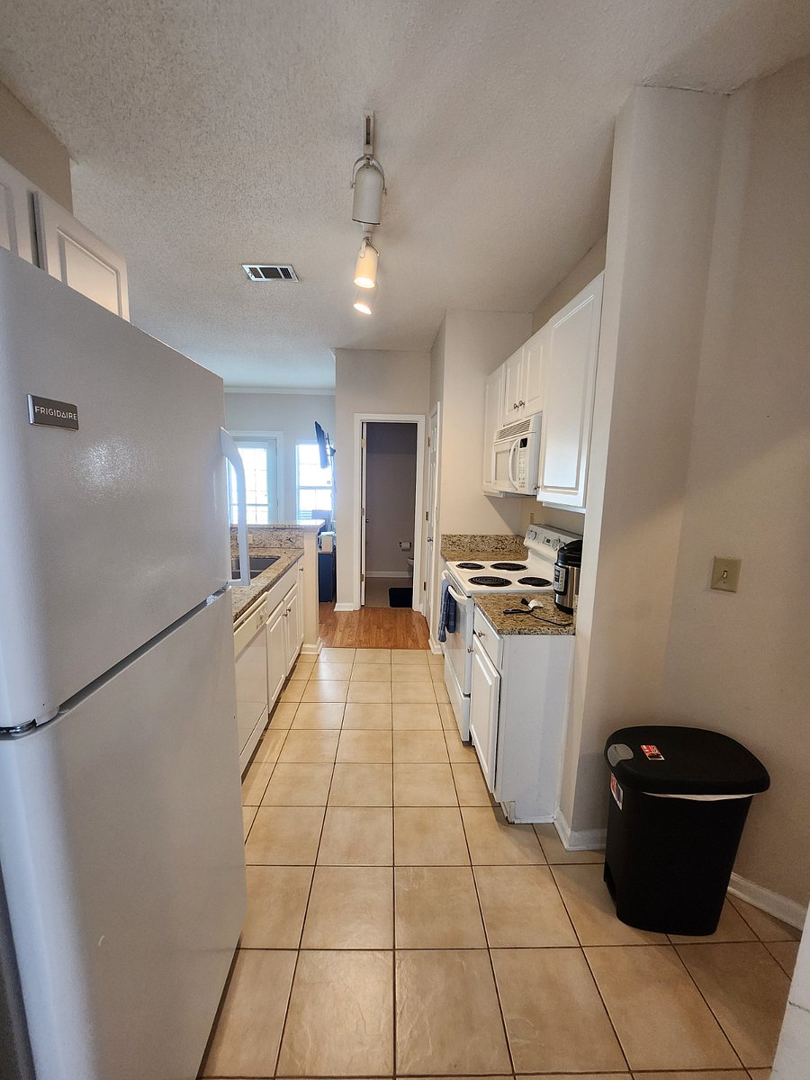 View of the kitchen from the dining room. You can see the half bath and the living room from here.
