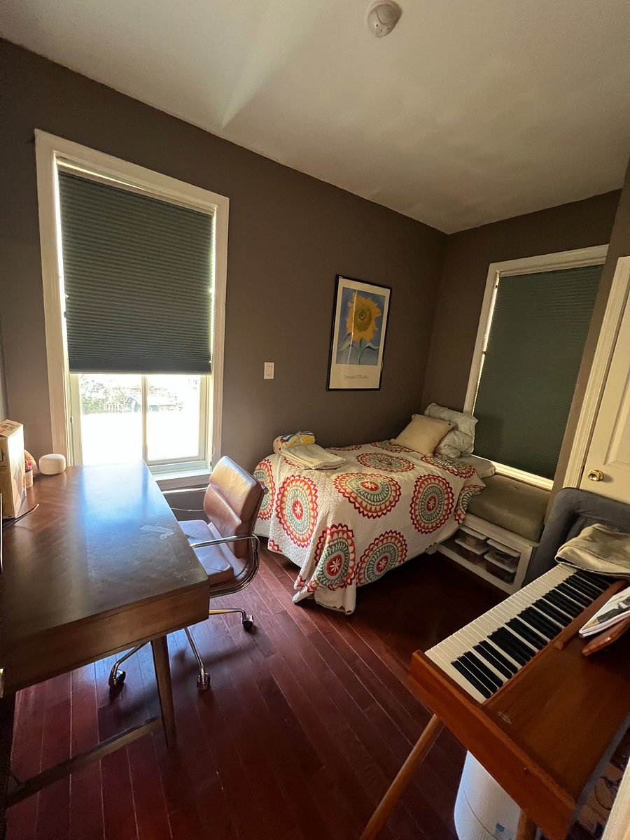 Bedroom with twin bed, desk, and piano.