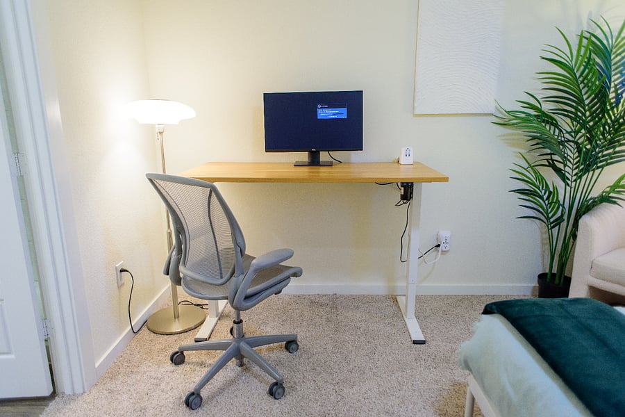 The desk raises and lowers electrically, shown here standing, with a USB charging station and solid gigabit internet, great for video calls.