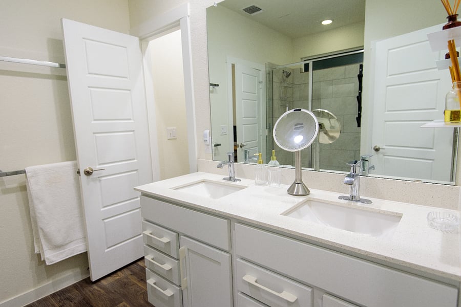 Private ensuite bath with a wide mirror, double vanity, and fresh towels provided.