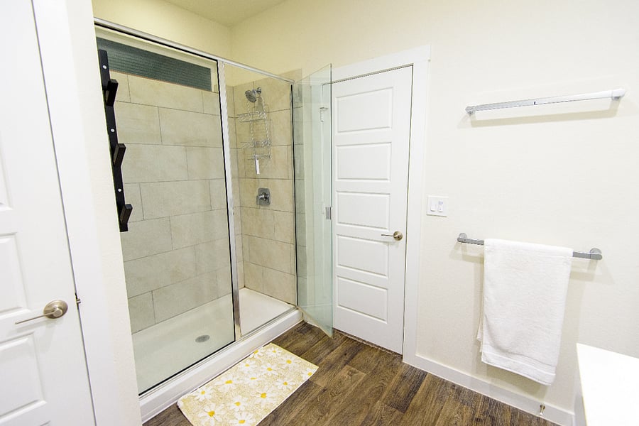 Walk-in glass shower with clean, modern tile.