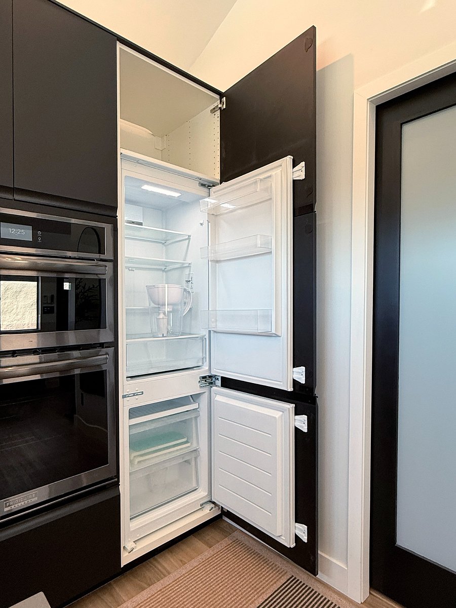 Integrated fridge is concealed by cabinet fronts.