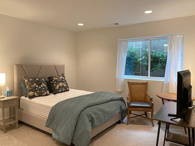 Spacious bedroom with queen bed, desk, tv and large closet
