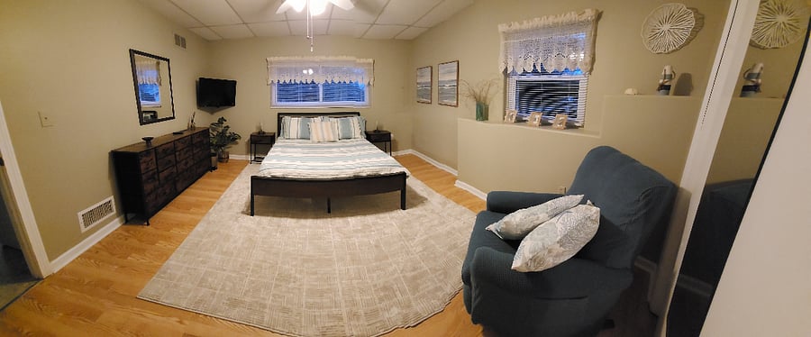 Main bedroom with platform bed, recliner and TV