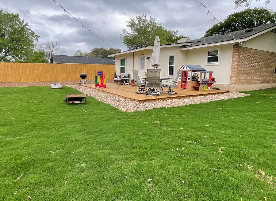 Large fenced backyard with BBQ grill, play house and connect 4 game & cornhole boards, table & chairs & additional seating. 