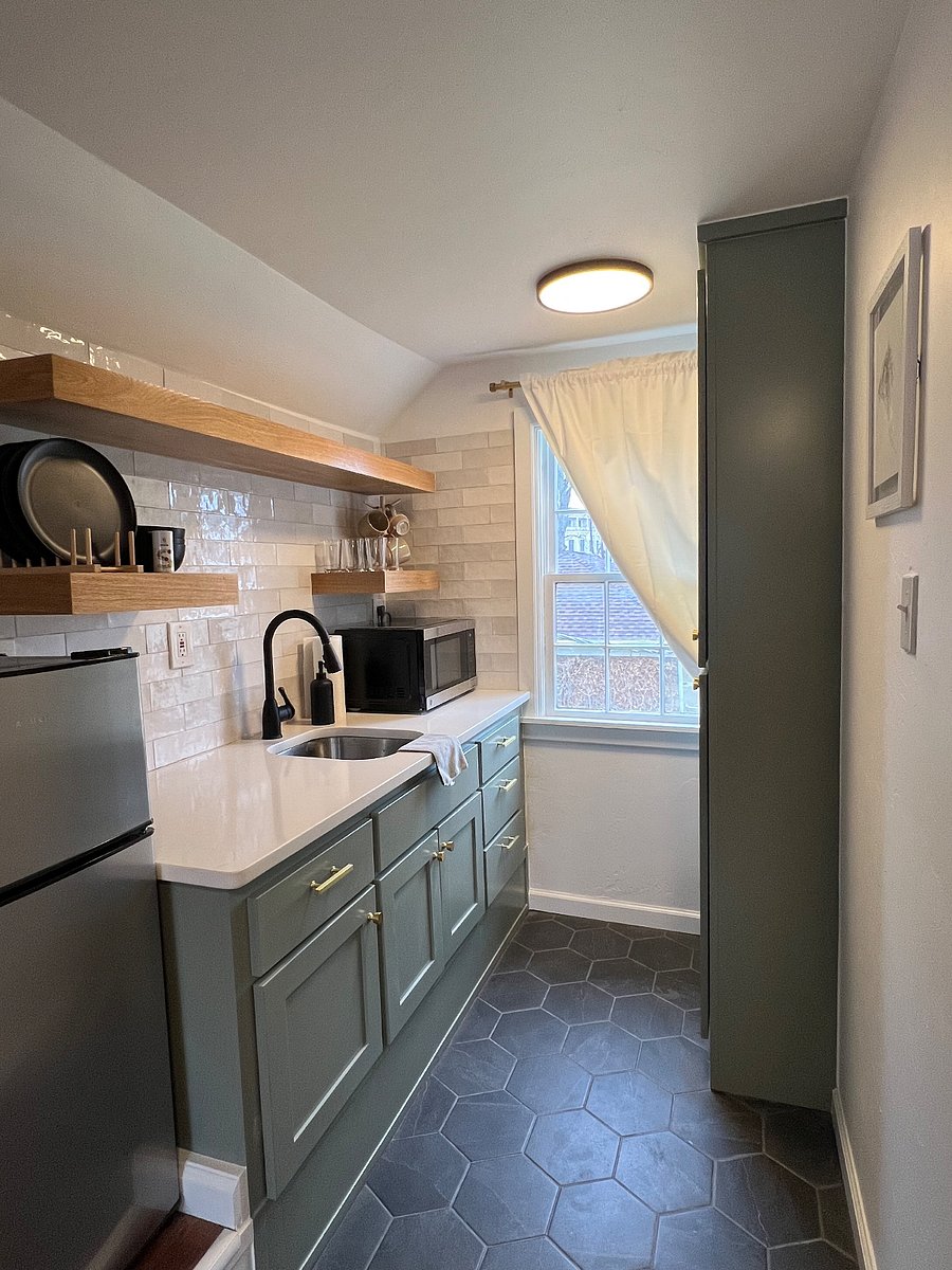 kitchenette equipped with microwave, air fryer, keurig, cups, mugs, plates, and utensils.
