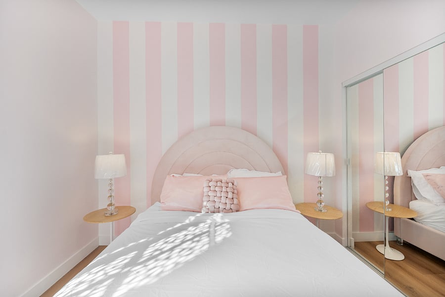 Queen bedroom with ceiling fan light, smart TV, and mirror closet