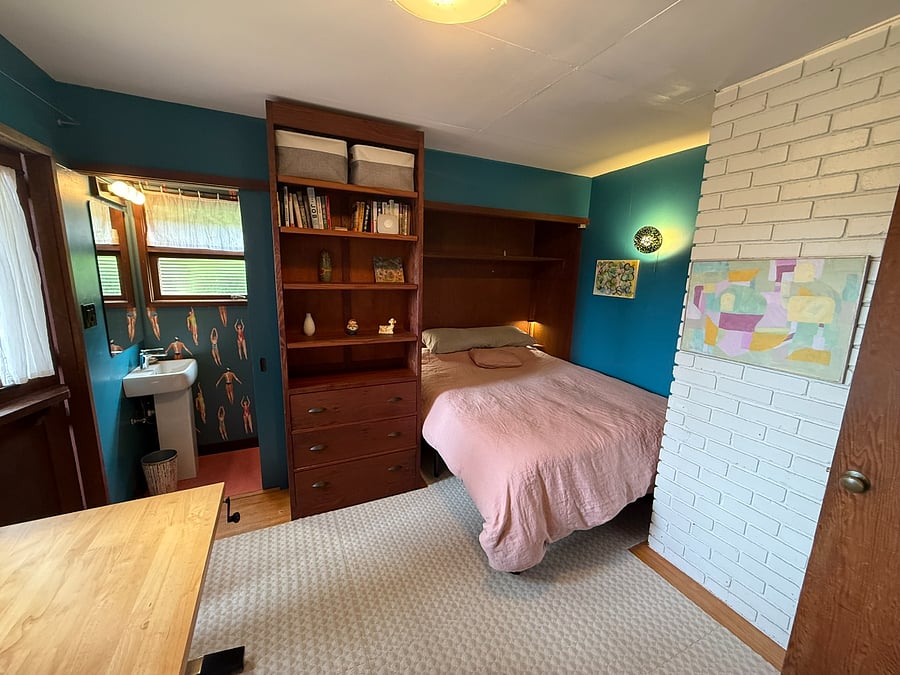 2nd flr bedroom with queen bed, 1/2 bath, door to yard & desk. There is no closet in this room but there are hooks on the back of door.