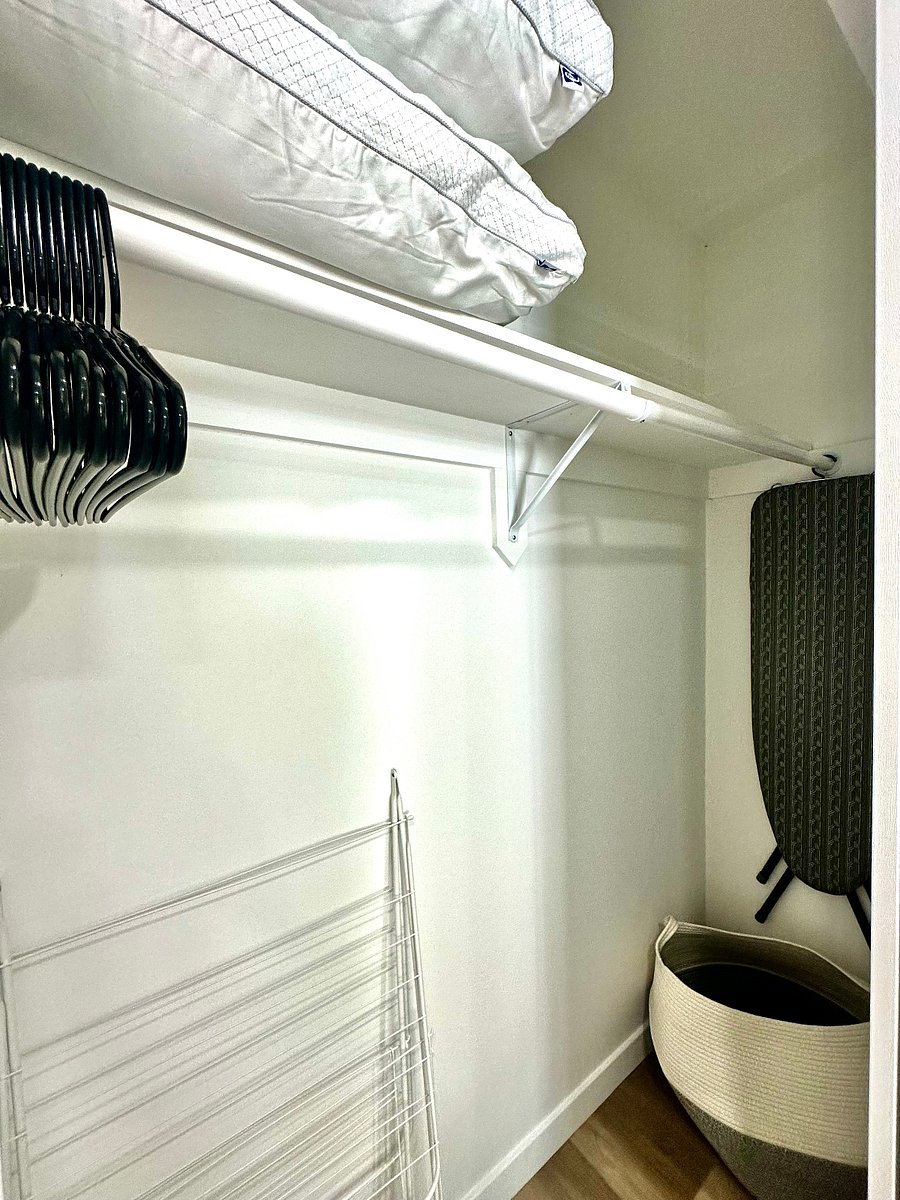 Full closet storage with hamper, drying rack, full-size ironing table and extra pillows for the living room queen sleeper sofa guest bed