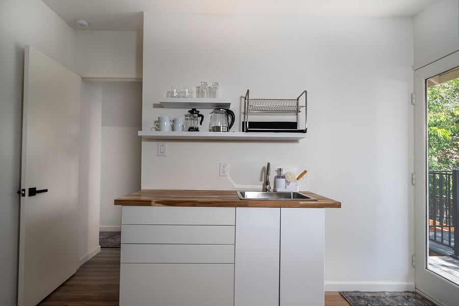 Food prep area. Kitchen is equipped with induction cooktop, toaster oven, microwave, hot water kettle, and full size fridge.
