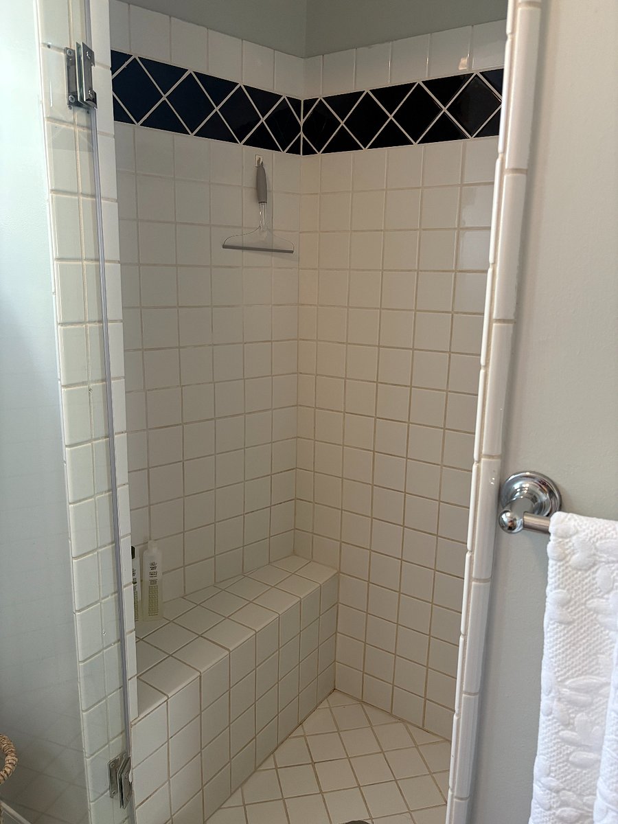 large tile shower with bench. separate part of bathroom with toilet