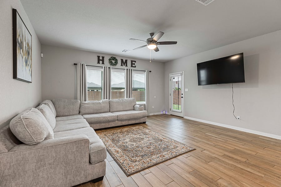 Large couch in the living room with 65 inch smart LED TV