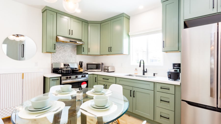 Green cabinet with black hardware. Beautiful light fixure and glass dining table. French door refrig and high capacty stove and range good. 