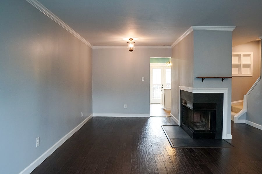 main floor living room (opposite angle), hardwood flooring, large bay window, wood burning fireplace