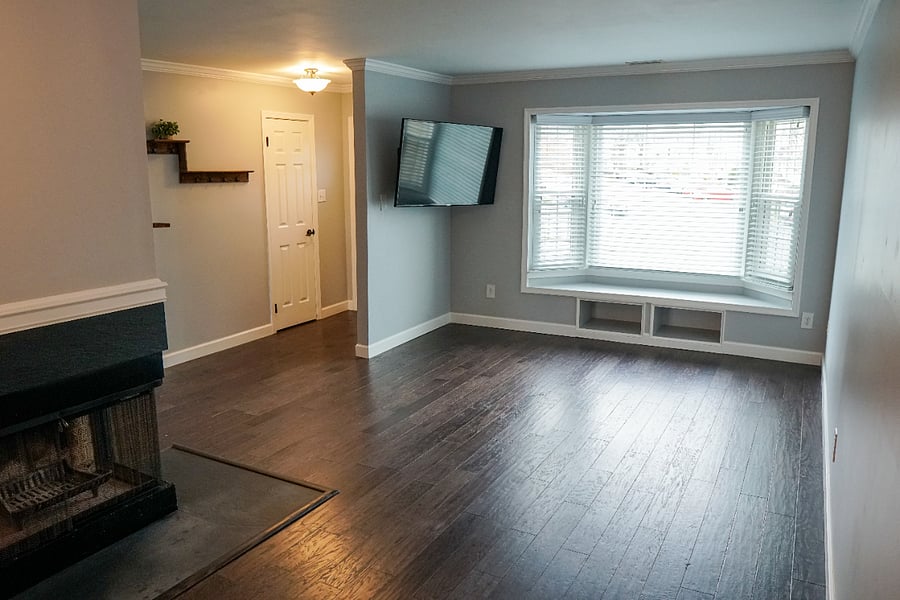 main floor living room, hardwood flooring, large bay window, wood burning fireplace
