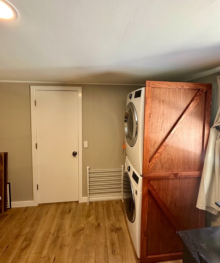 View of door in shared laundry area leading to the apartment. Laundry room is a shared with the other unit.