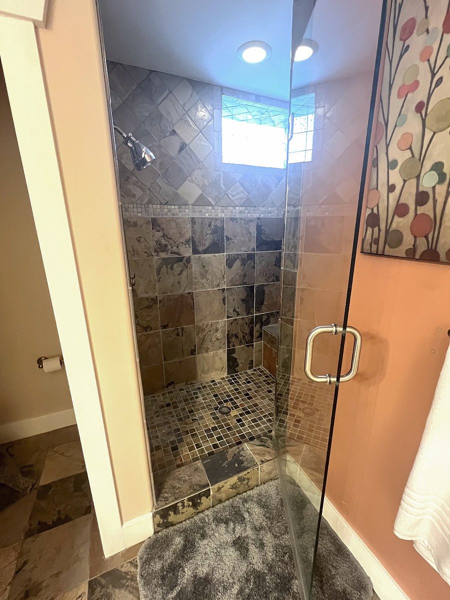 Spacious shower with 2 heads and a bench seat