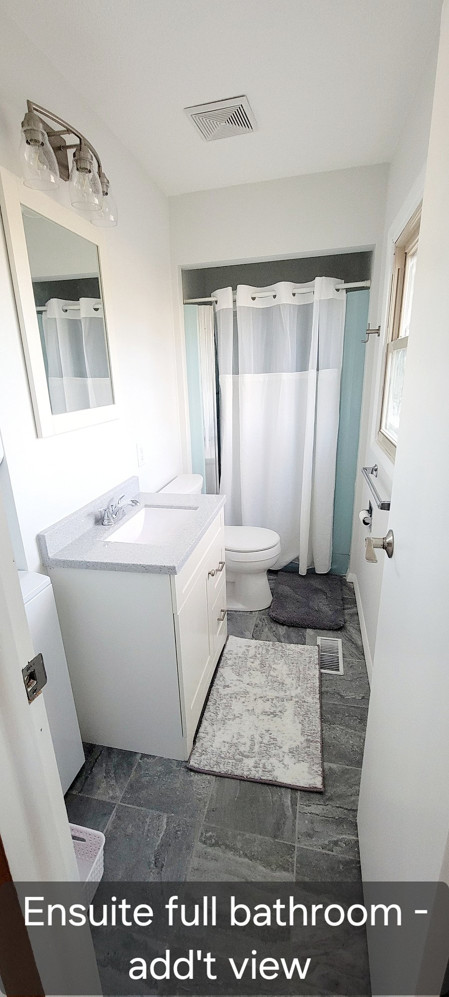 Ensuite master bathroom. Shower, toilet, vanity, mirror, stack washer and dryer, cleaning products