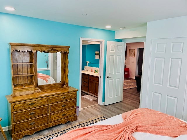 Spacious dresser with a mirror. View into master bathroom.