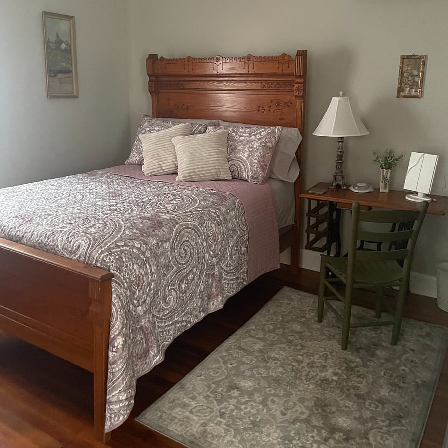An upstairs bedroom has a full-size bed with dresser and closet space.