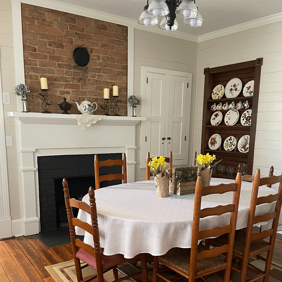 The dining room features the original fireplace with exposed brick.