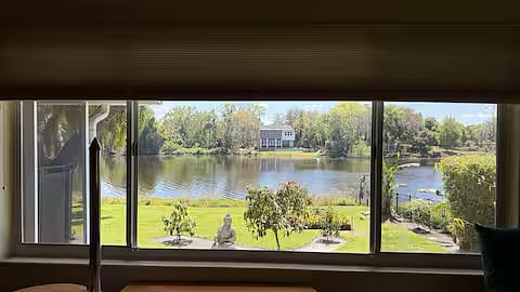 Enjoy the serenity of a stunning panoramic view of a spring-fed lake right from your own fully furnished studio. Whether you're sipping your morning coffee or relaxing in the evening, this picturesque setting offers a peaceful retreat after a busy day. This studio includes a spacious walk-in closet, private parking in a beautifully designed circular paver driveway, and a cozy, well-appointed living space area, complemented by the natural beauty of the lake.