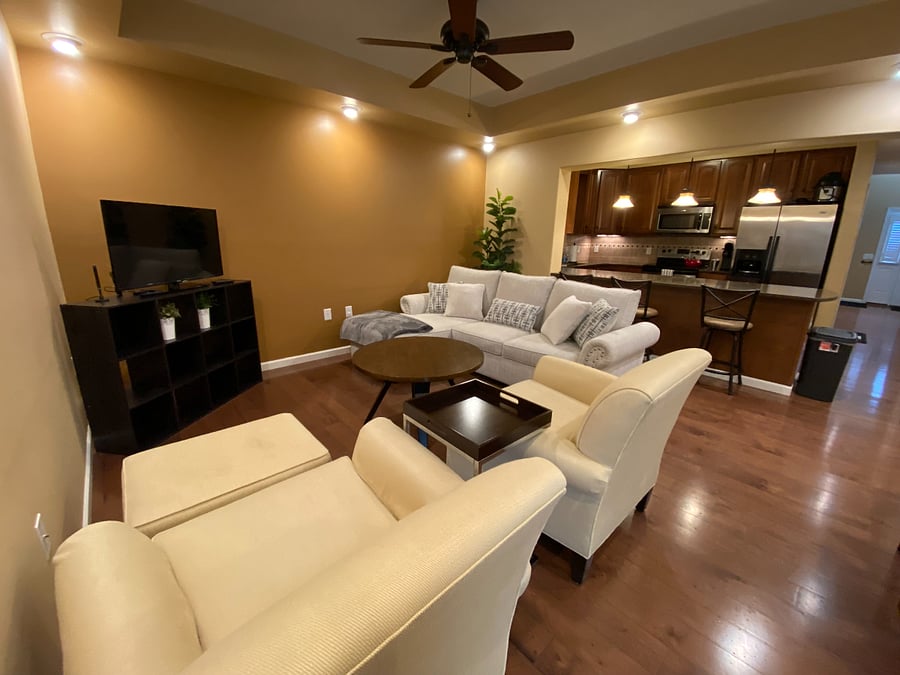 Embrace the open flow of this well-lit interior living and dining area. This inviting space features 9 ft. ceilings, a six-top dining table, a comfortable sofa (which also converts to a bed), and two cozy armchairs. A sliding glass door leads to a small back patio, bringing in natural light. The convenient bar area offers a seamless connection to the kitchen, perfect for socializing. Ready to relax and connect? The living area comes equipped with included WiFi and a TV with Roku, perfect for streaming your favorites!