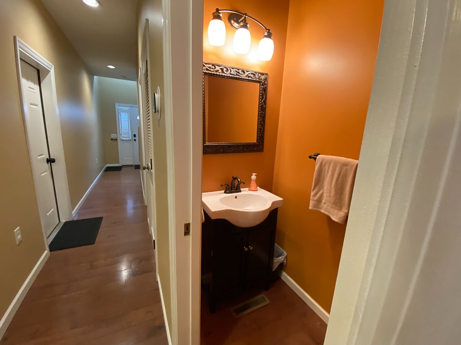 The first-floor hallway links the main entrance to the open-concept living, dining, and kitchen area. You'll find a convenient half bath along this hallway. The unit also includes a smart thermostat for your comfort.