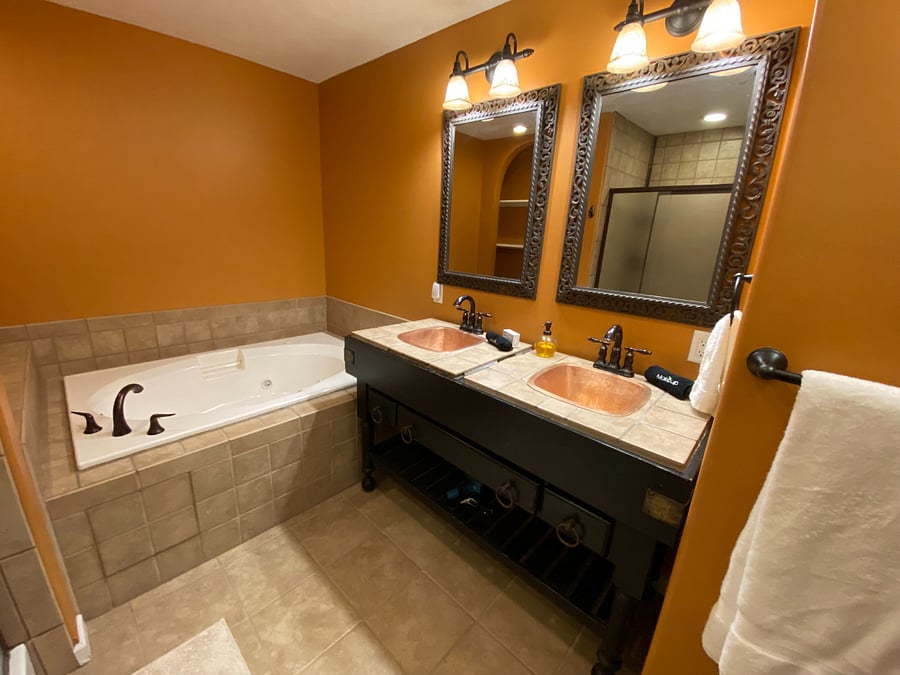 The primary bathroom is designed for both comfort and functionality, offering a double vanity, a relaxing jacuzzi tub, a separate shower, and a private toilet area.