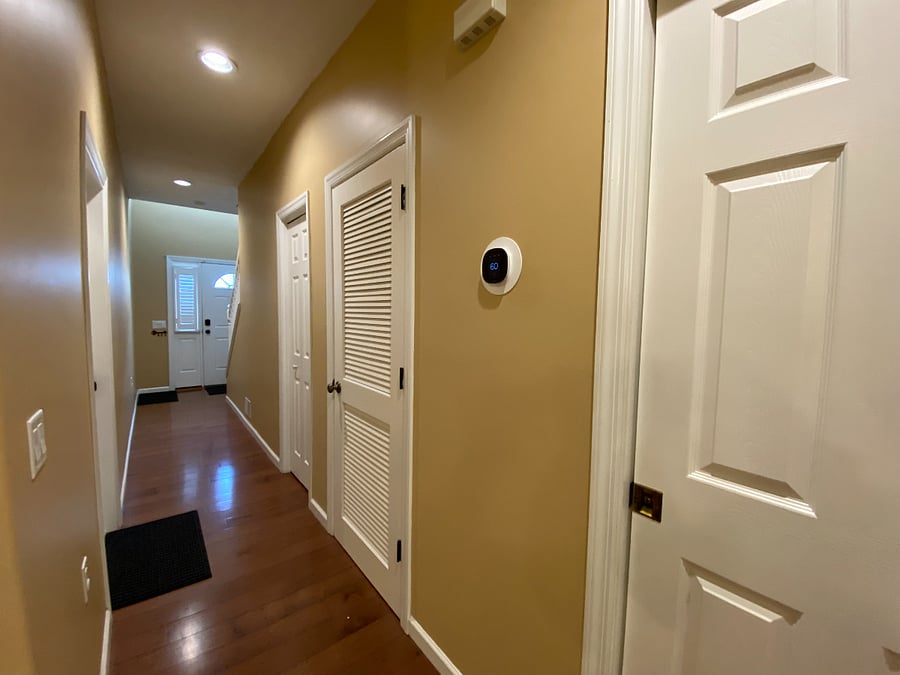 The first-floor hallway links the main entrance to the open-concept living, dining, and kitchen area. You'll find a convenient half bath along this hallway. The unit also includes a smart thermostat for your comfort.