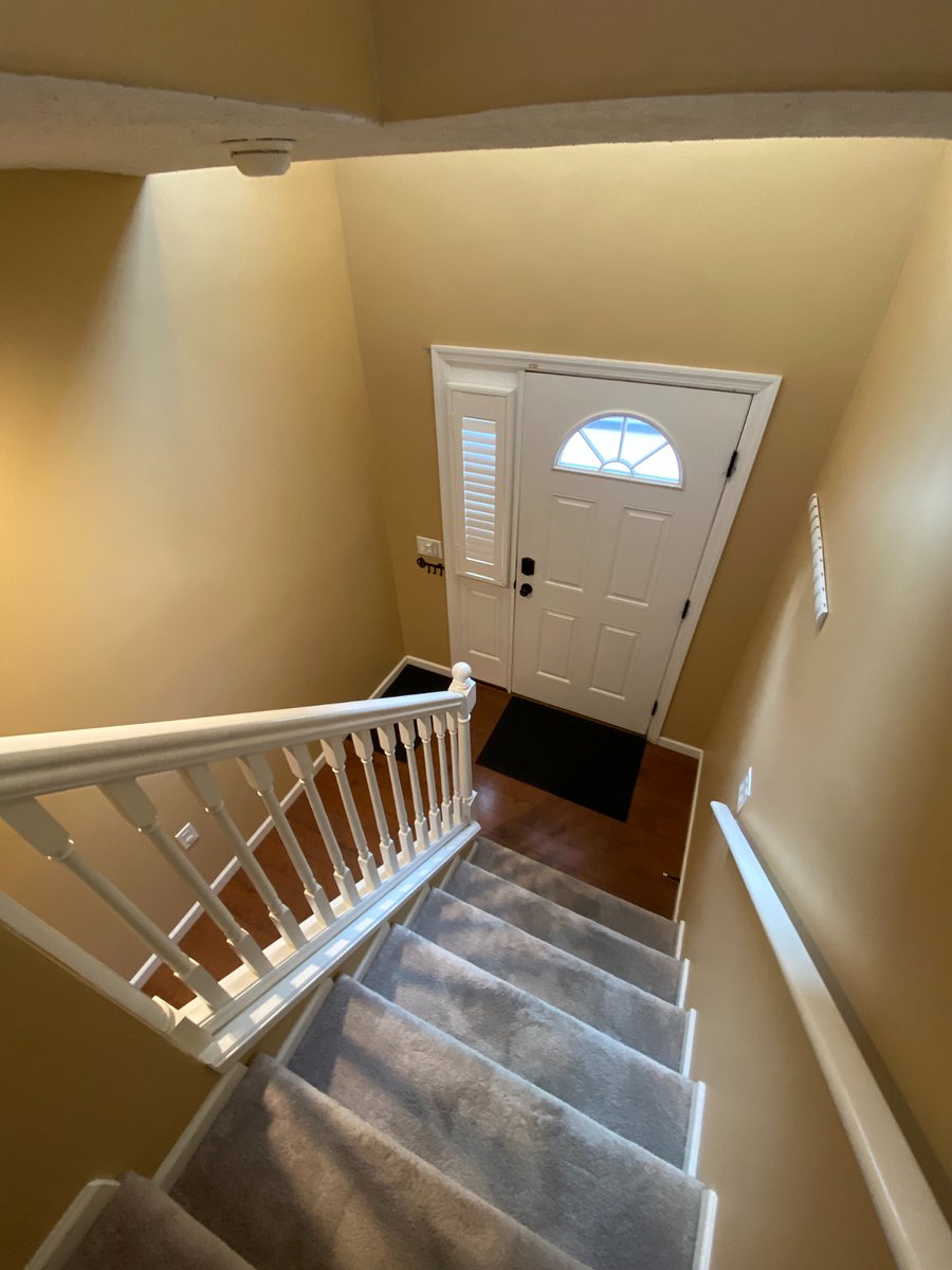 Stepping downstairs, you'll find a compact yet bright entryway. Despite its size, the soaring ceiling opens up to the second floor, allowing an abundance of natural light to flood the space.