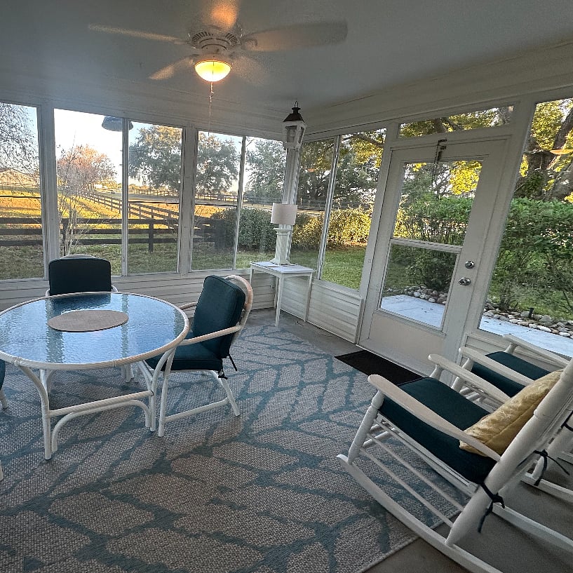 GLASSED-IN LANAI, BACK DOOR. Dining table seats 4. New Sunbrella blue cushions. Lighting.