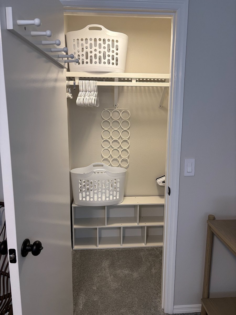 GUEST BEDROOM CLOSET: Brightly lit with ample storage on solid wood shelves. Luggage rack.