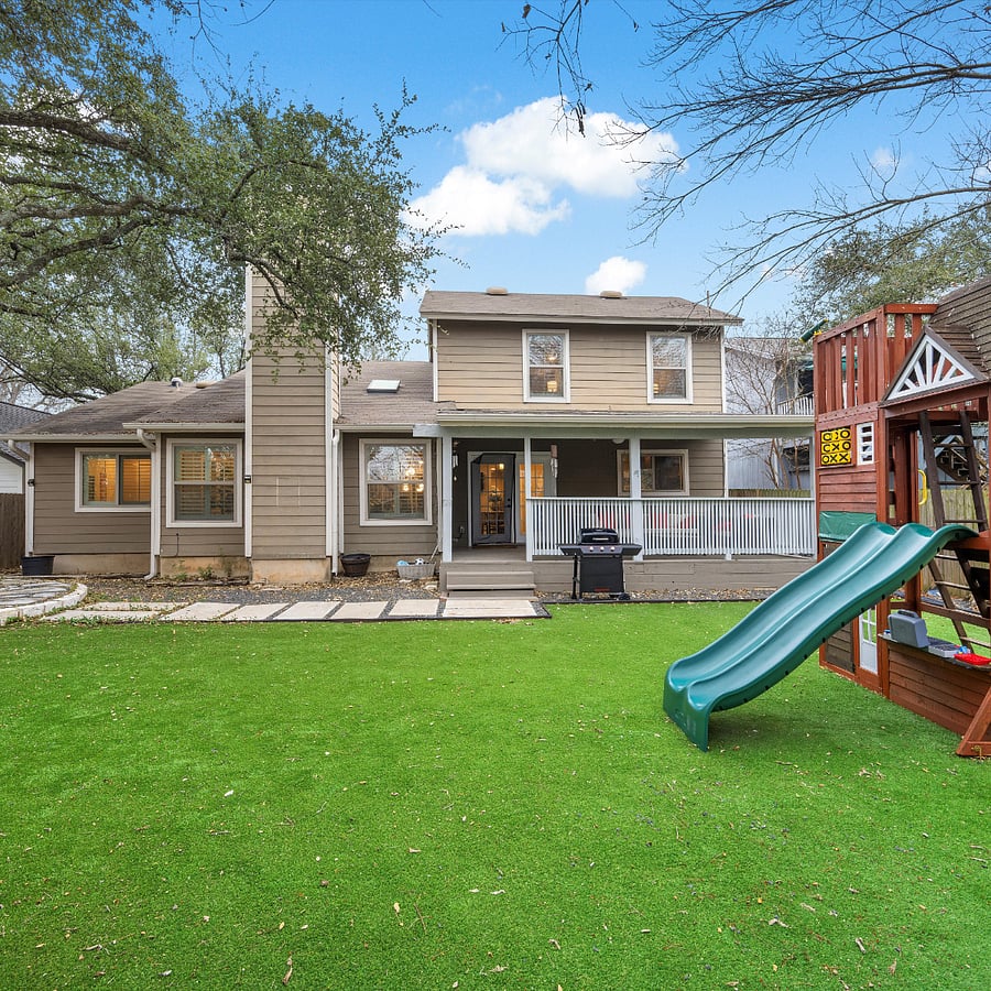 Backyard with playground, turf, and plenty of room for furry friends.