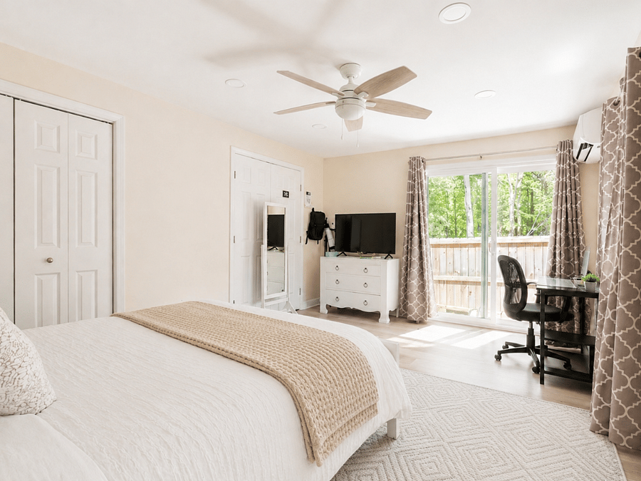 King bedroom with blackout treatments and dedicated work desk.
