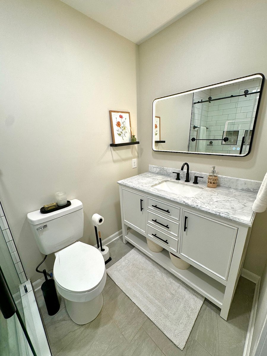 Fully remodeled master bathroom with tile floors, light up mirror, & tile shower with dual shower heads 