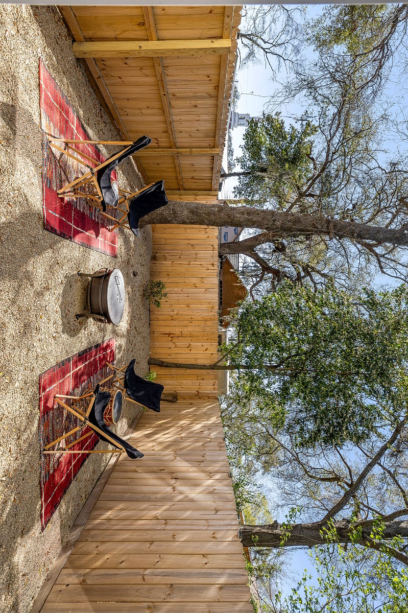 Super low maintenance backyard with stone throughout and some trees and bushes. The vibe is inviting and ready for storytelling around the firepit.