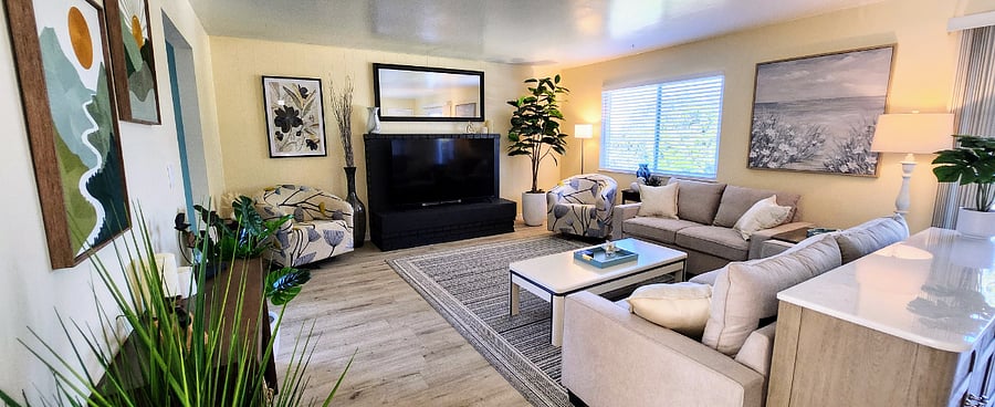 Living room w/ 70" smart TV and 2 cozy corners for reading.