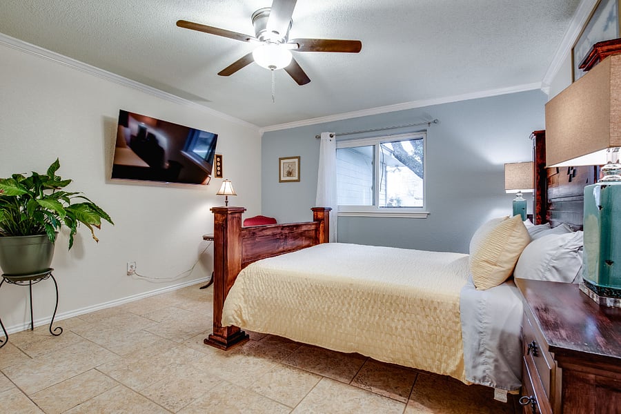 Bedroom 1, Master Suite, with queen bed, ceiling fan, 55" smart TV, private bathroom with tub and shower, and 2x walk-in closets
