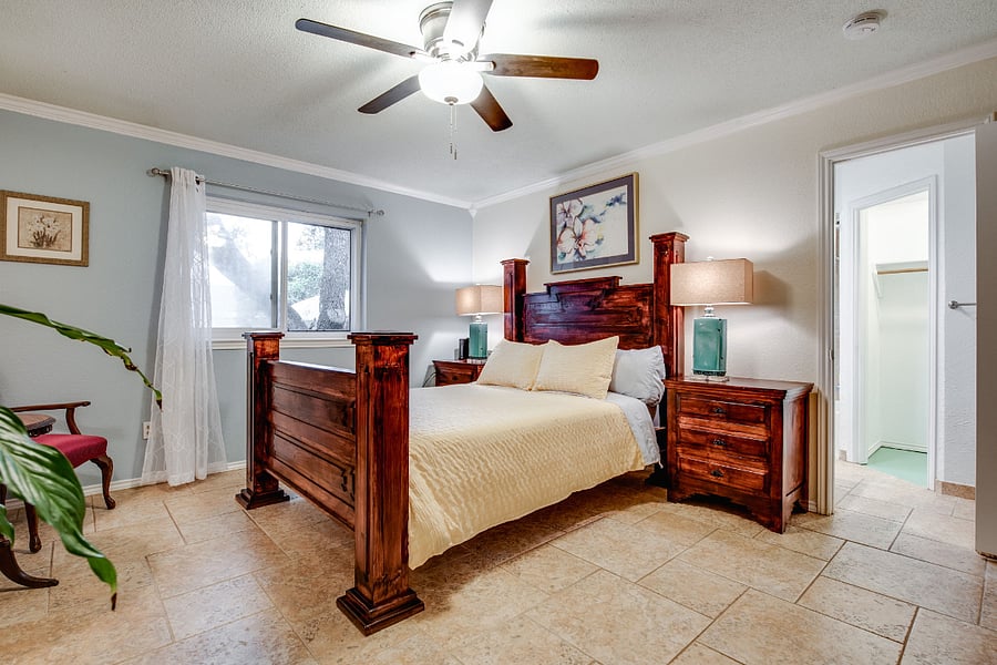 Bedroom 1, Master Suite, with queen bed, ceiling fan, 55" smart TV, private bathroom with tub and shower, and 2x walk-in closets
