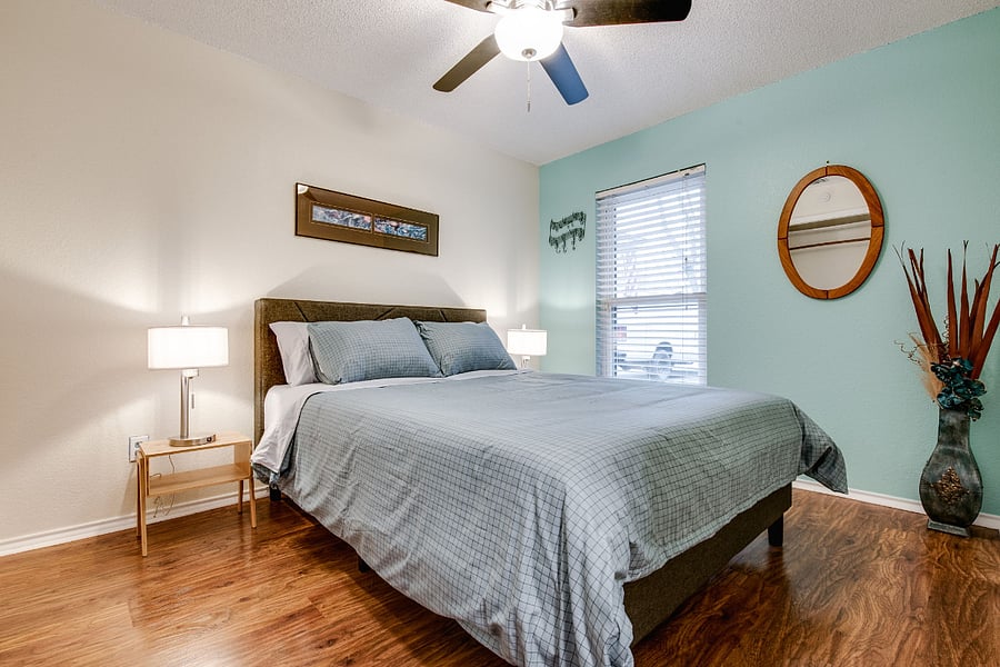 Bedroom 3, with queen bed, ceiling fan, smart TV, walk-in closet, and a view of front yard.
