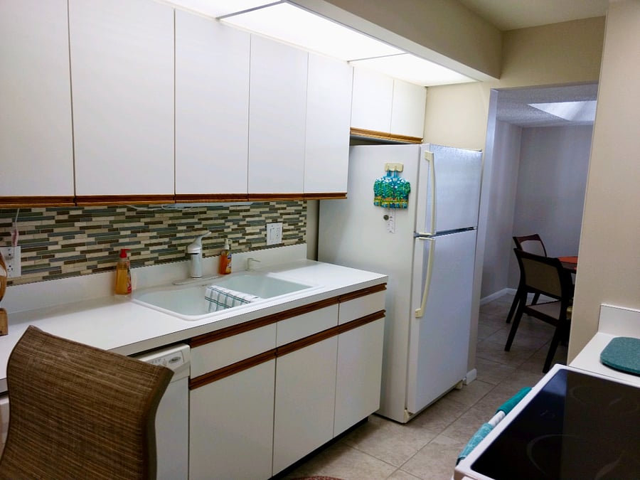 The kitchen features a refrigerator/freezer, microwave, oven, toaster, and coffee maker.