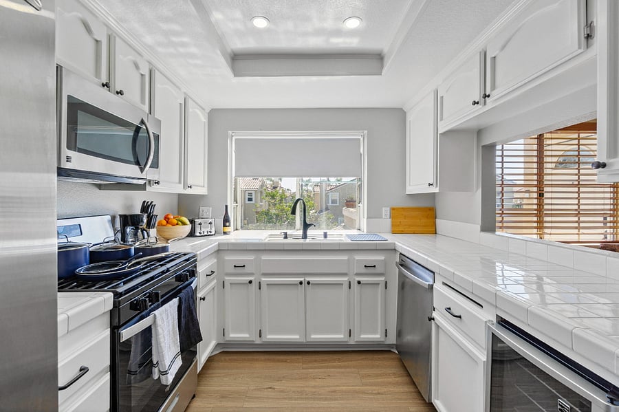 Bright fully equipped kitchen with stainless steel appliances including dishwasher and wine cooler. Plenty of countertop space and storage,