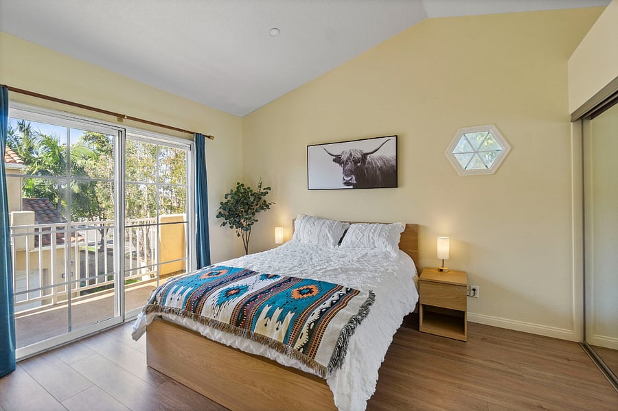 Large bright master bedroom with queen bed, vaulted ceilings and private balcony. Includes two separate large closets.