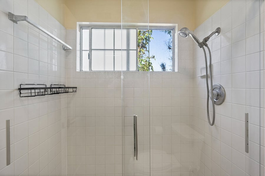 Separate bright bathroom with walk in shower just off master bathroom vanity area.