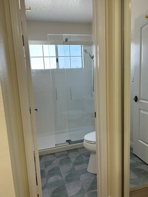 Separate bright bathroom with walk in shower just off master bathroom vanity area.